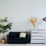 a couch and a dresser and light staged for a room