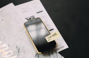 a mobile device with a prompt that says sign here