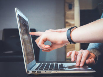 a person pointing at a computer screen