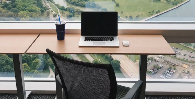a computer on a desk near a window