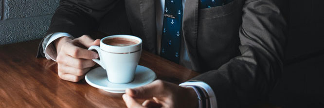 a person in a business suit with a cup of coffee