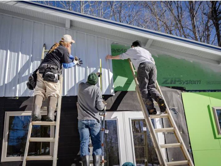 people working outside a house