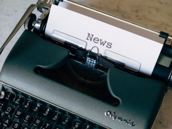 a typewriter with paper that says news in it