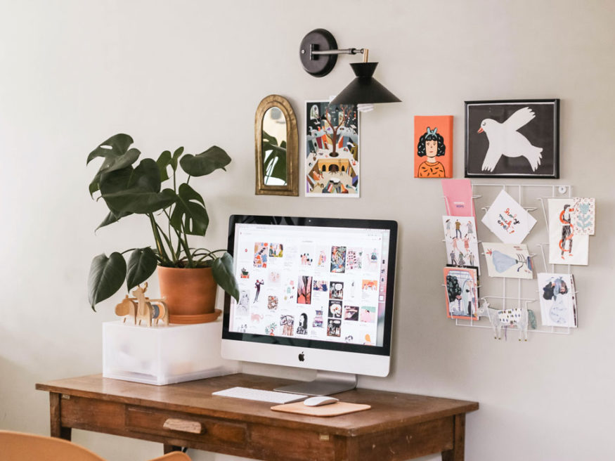 a computer on a desk with a bunch of stuff on the wall